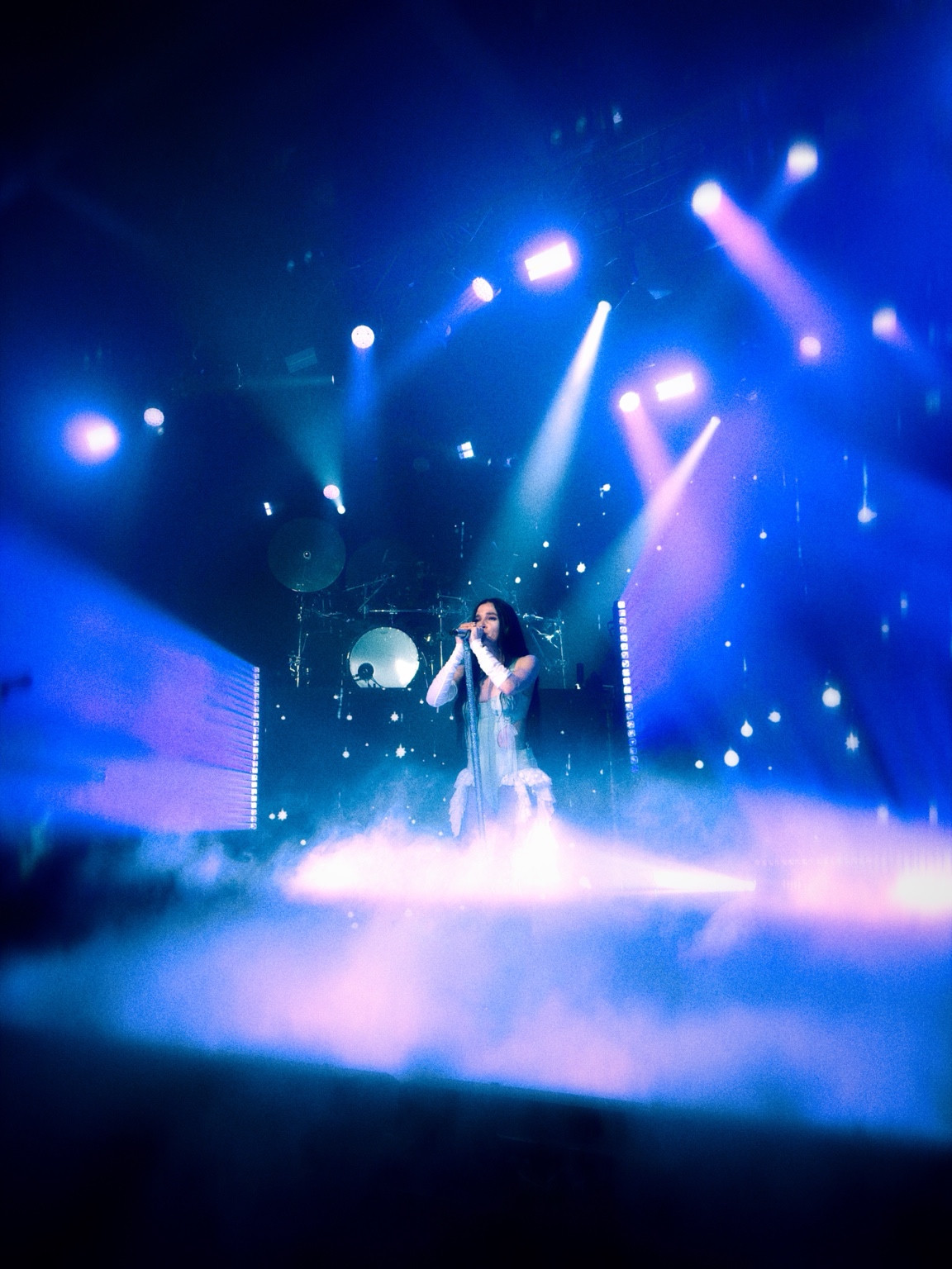 Poppy singing in blue light and stage haze